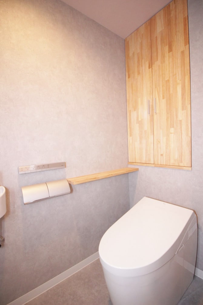 グレーと木の扉の収納がおしゃれな落ち着いた雰囲気のトイレ｜横浜リノベーション