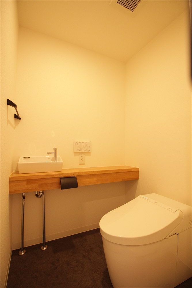 ダークトーンの床と木材アクセントのトイレ｜リノベーション横浜